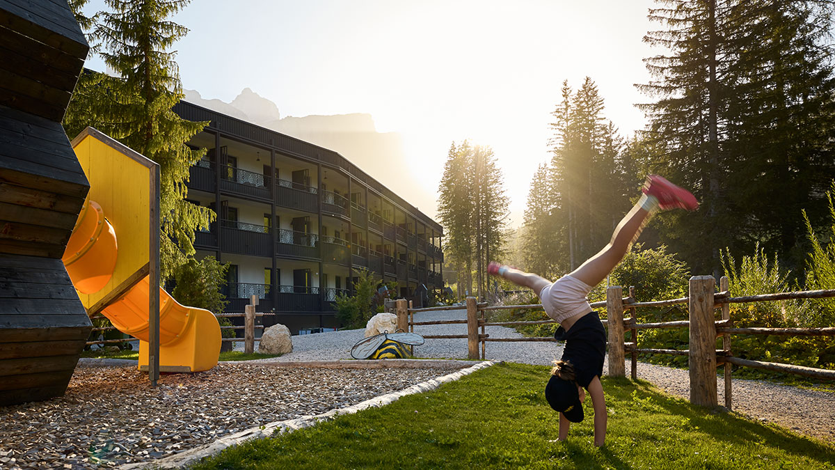 Familienhotels Südtirol: 4 neue Mitglieder 1 Kind tobt vor dem neuen Mitglied der Familienhotels Südtirol dem Movi Family Apart Hotel