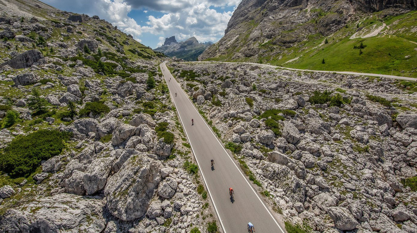 Ladiner-Identität auf zwei Rädern 1 Mehrere Radfahrer radeln durch die Landschaft der Dolomiten, das schafft Ladiner-Identität