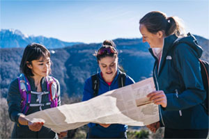 Frauen auf die Spitze 2 Frauen orientieren sich in der Bergwelt an einer Landkarte