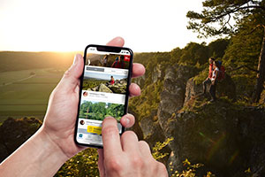 Digitale Wandernadel für Wege in Deutschland 2 Ein Paar wandert und sammelt mit seinem Smartphone Punkte, mit denen es später belohnt wird ©Top Trails of Germany