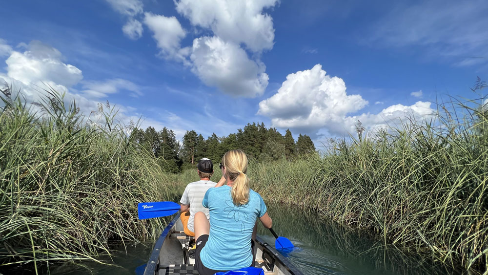 Erst schwitzen, dann im Faaker See baden 4 Zwei Personen fahren durch einen Schilfgürtel im See