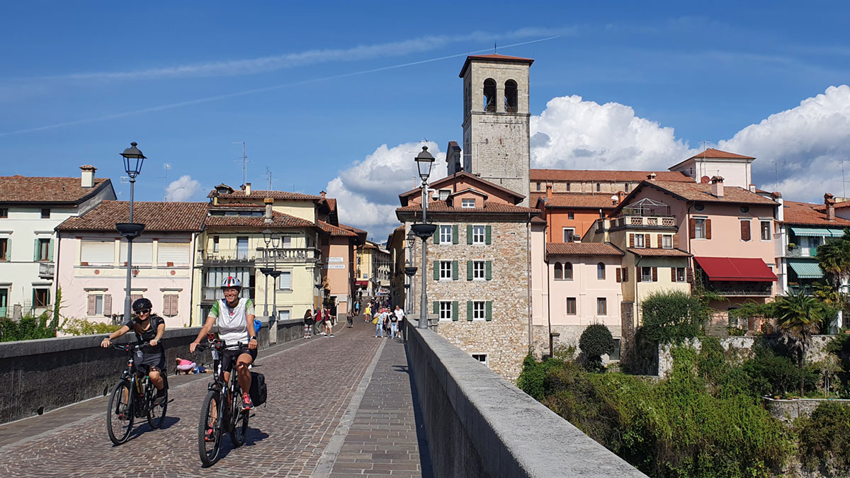 Neues Radlerparadies: Udine und Umland 4 a man riding a bicycle on a bridge over a river in Udine