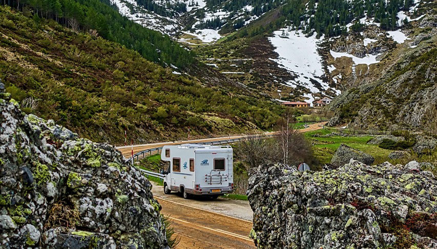 11 Gründe, warum Camping süchtig macht 3 Ein Wohnmobil fährt durch eine Berglandschaft