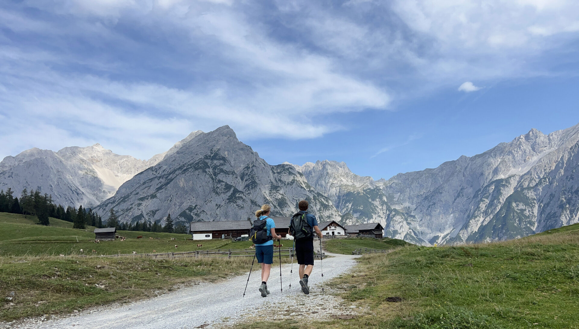 Bergsagenweg – Weitwandern mit Riesen und Berggeistern 1 Mann und Frau wandern auf die Walder Alm zu, während sie auf dem Bergsagenweg unterwegs sind