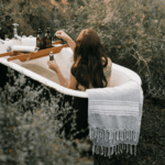 4 x Outdoor-Hygiene für unterwegs 3 Eine Frau mit langen Haaren sitzt im Freien in einer Badewanne