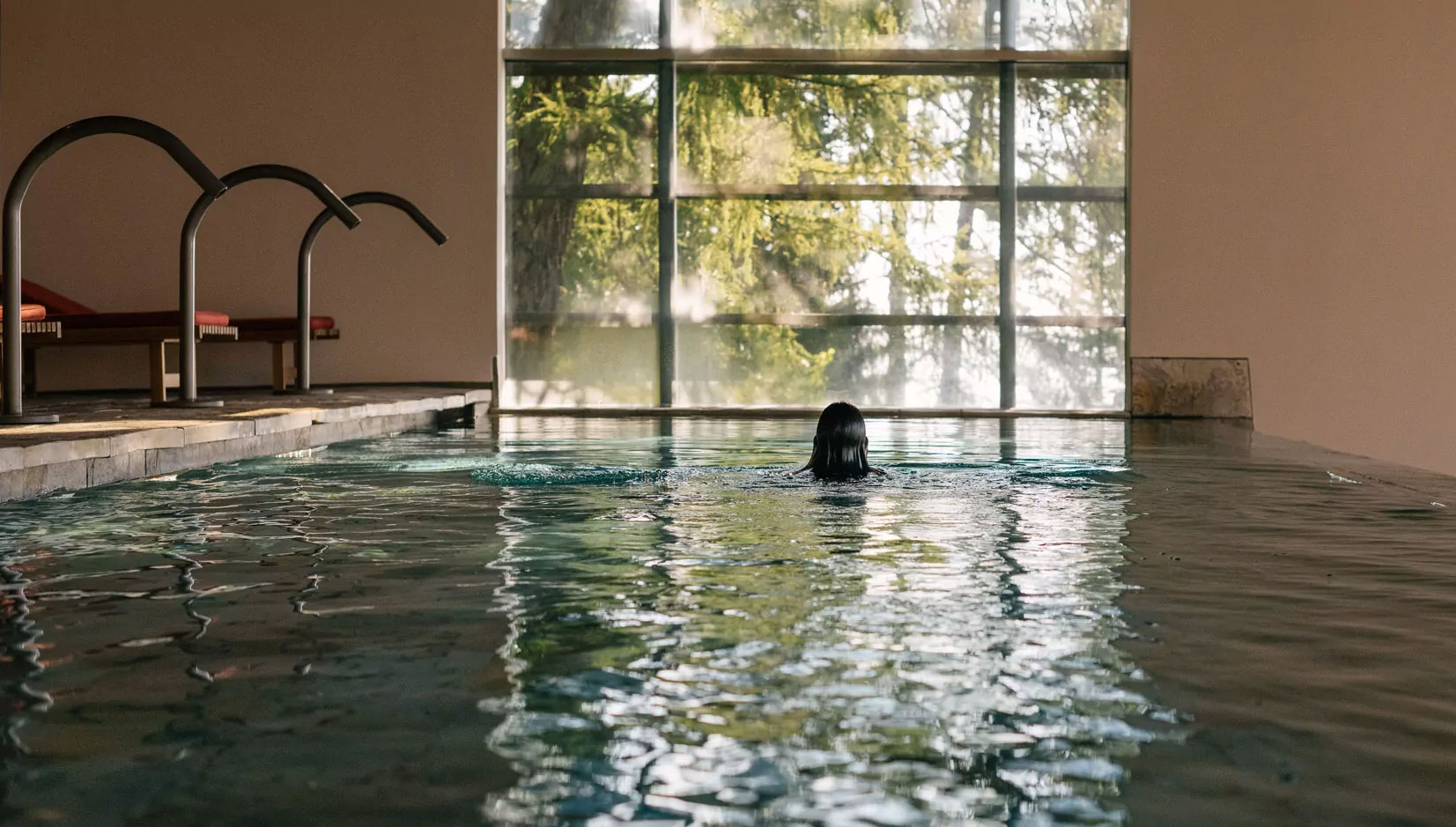 15 Erholungsorte, die Stil und Zeitgeist atmen 5 Frau schwimmt in einem stilvollen Hotelpool