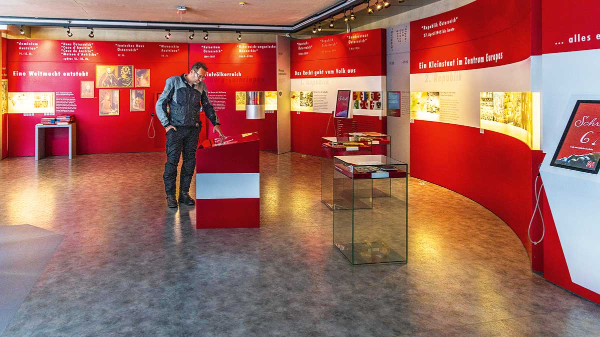 Österreichtouren für alle Sinne 2 Ein Mann steht in einem Museum vor der Österreichs Flagge