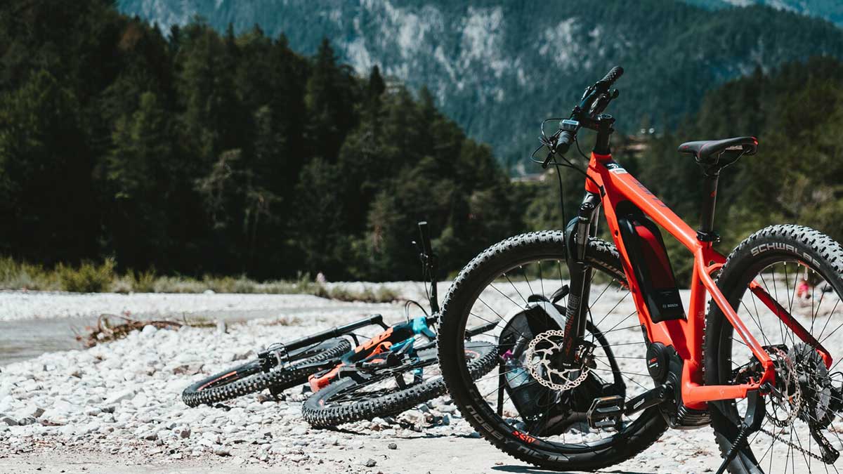 Für den frühen Wurm: Frühlingsurlaub in den Alpen 2026 3 Zwei Fahrräder irgendwo in den Alpen, eins steht eins liegt