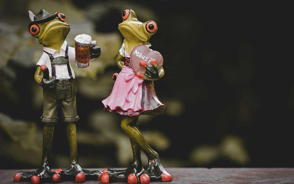 Tradition mit Augenzwinkern: Zwei Froschspielzeuge im Dirndl zeigen, dass Alpenkultur auch verspielt sein kann
